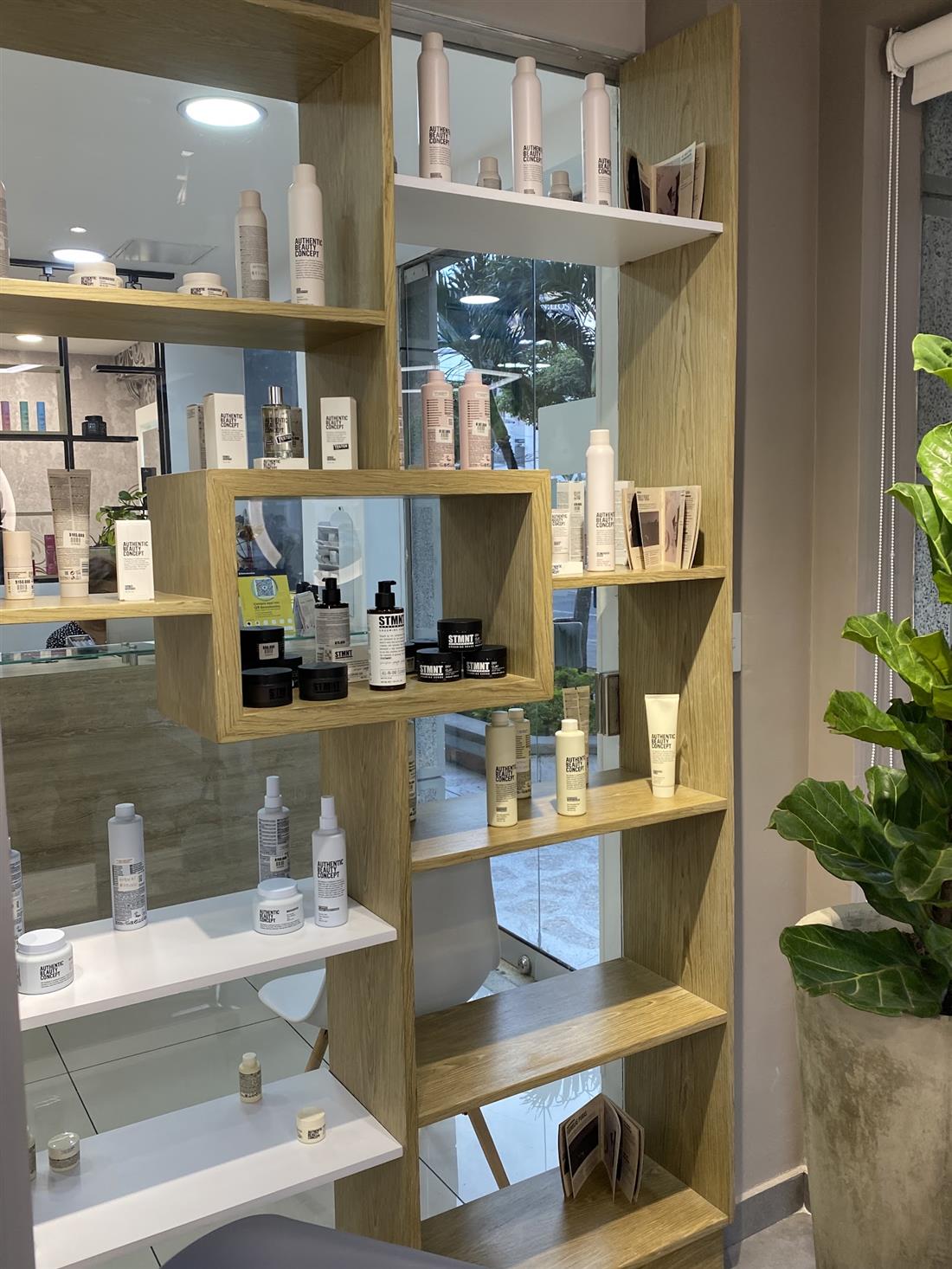 Estantería de madera clara con productos profesionales para el cabello